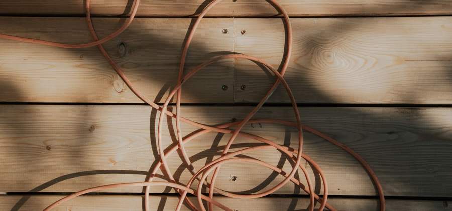 Câble électrique souple déroulé en boucles sur un plancher en bois clair