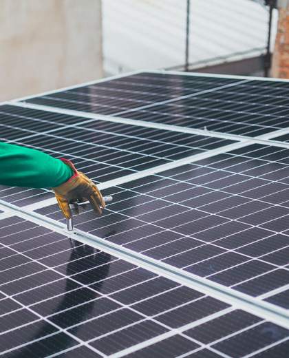 Technicien casqué fixant des panneaux photovoltaïques en toiture