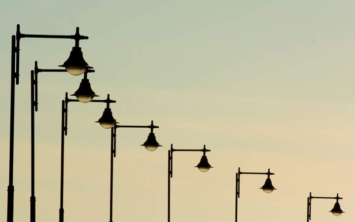 Rangée de lampadaires d’éclairage public en silhouette sur un ciel de crépuscule