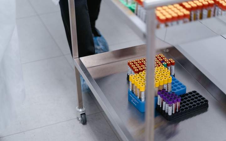 Tubes de prélèvement sanguin à bouchons colorés rangés sur un chariot en inox de laboratoire