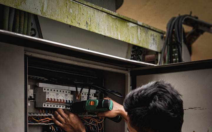 Technicien intervenant sur le câblage d’un tableau électrique