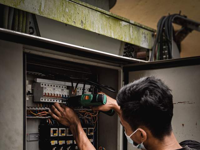 Technicien intervenant sur le câblage d’un tableau électrique