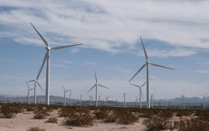 Parc éolien terrestre avec plusieurs éoliennes sous un ciel nuageux